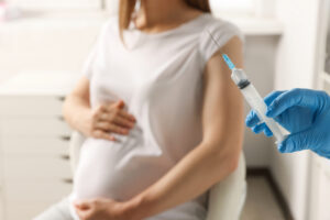 Doctor giving injection to pregnant woman in hospital, closeup