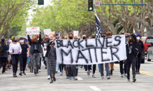 Alameda, CA - Apr 24, 2021: Unidentified participants holding signs at a youth lead End Police Brutality March marching from Washington Park to Alameda Police Station for a rally. Alameda, CA - Apr 24, 2021: Unidentified participants holding signs at a youth lead End Police Brutality March marching from Washington Park to Alameda Police Station for a rally.