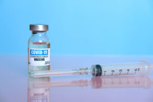 Ampoule with COVID-19 coronavirus vaccine, with a syringe for vaccination
