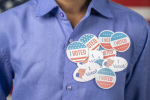 Close up of multiple I Voted stickers on blue shirt - Concept of US election voter fraud by placing multiple voting stickers.