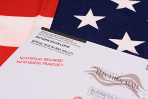 Return envelope for official vote by mail ballot. Background the flag of the United States. Selective focus. - San Jose, California, USA - October 8, 2020 Return envelope for official vote by mail ballot. Background the flag of the United States. Selective focus. - San Jose, California, USA - October 8, 2020